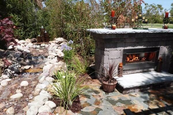 outdoor propane fireplace with stream next to it